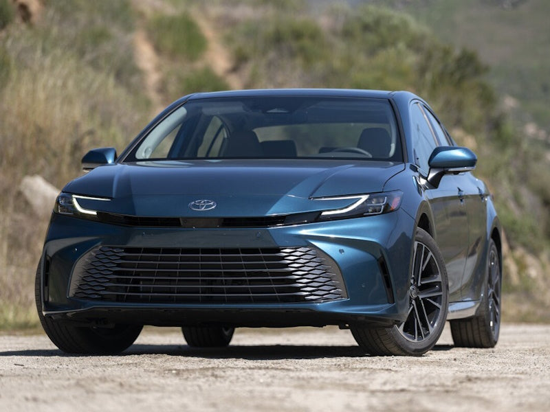 Blue Toyota car parked on a dirt road.