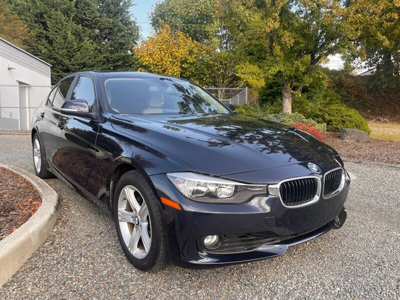 Dark blue BMW sedan parked outdoors.