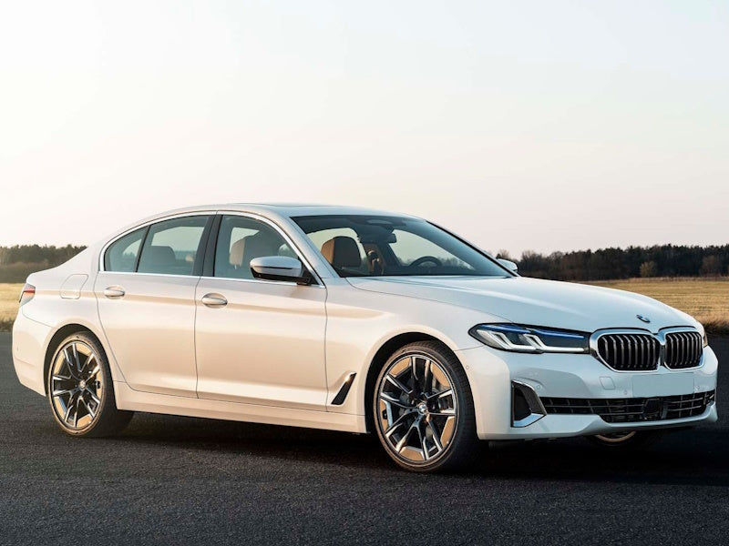White BMW sedan parked on a road.