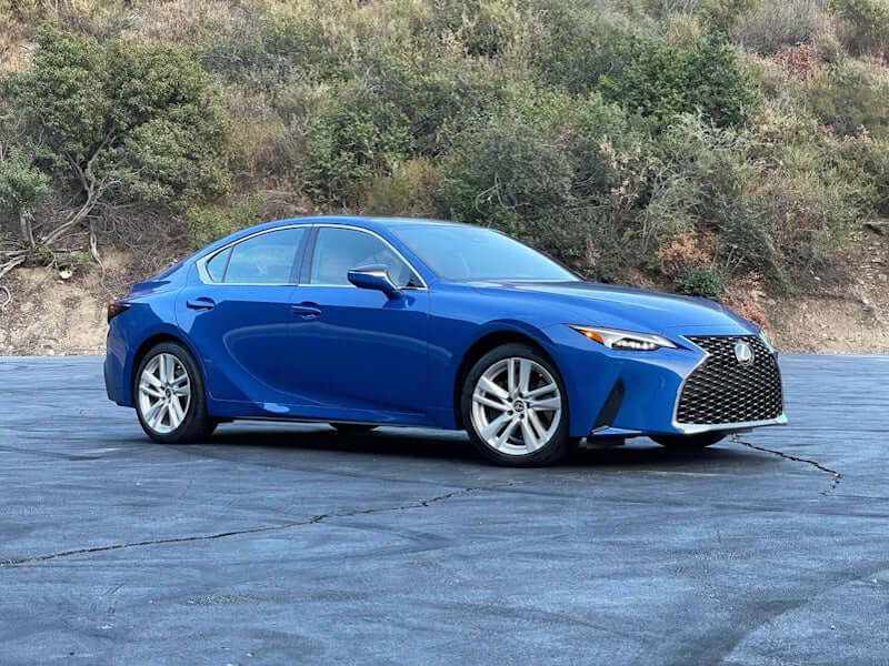 Blue sedan parked on pavement.