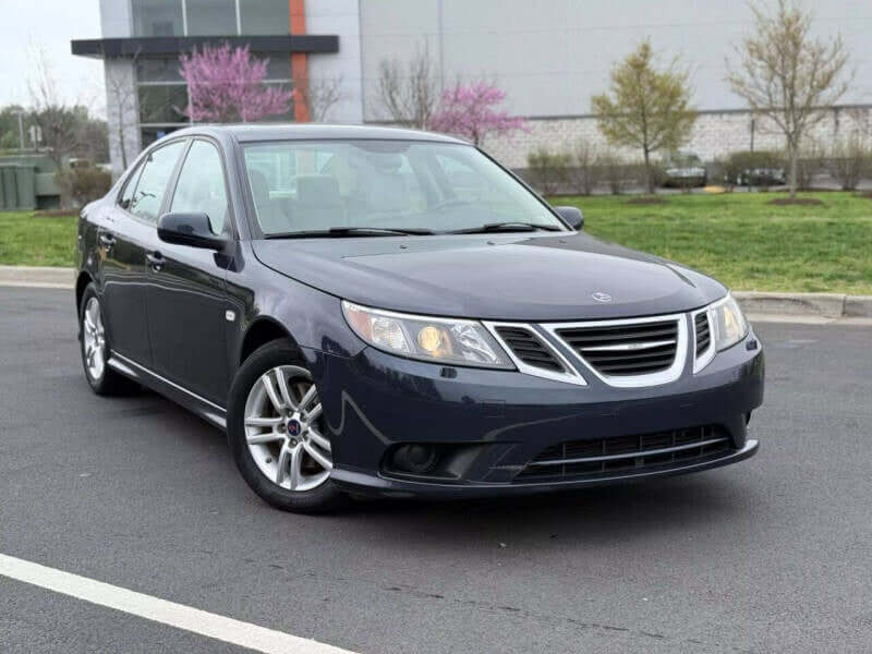 Dark blue Saab sedan parked on asphalt.